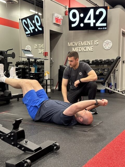 Adam, a personal trainer and kinesiologist at Studio Fit U with a client working on lower back strength